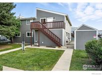 Two-story exterior with gray siding, a wooden deck and stairs leading to the entrance at 3790 Iris Ave # D, Boulder, CO 80301