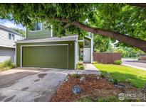 Inviting two-story home with a well-maintained lawn, green siding, and a two car garage at 4129 Amber St, Boulder, CO 80304