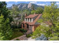 Charming brick home with mountain views surrounded by lush greenery and mature trees at 755 Lincoln Pl, Boulder, CO 80302