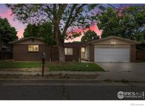 Charming single-story brick home with a well-maintained lawn and a two-car garage and mature trees at 11378 W 68Th Way, Arvada, CO 80004