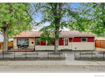 Charming single-Gathering home with lush trees and a well-manicured front yard at 1514 Collyer St, Longmont, CO 80501