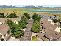 Aerial view of townhomes near lake, showcasing lush greenery and mountain views at 211 Rockview Dr, Superior, CO 80027