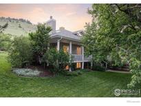 Inviting home with a manicured lawn and lush trees offering both curb appeal and a sense of privacy at 3421 4Th St, Boulder, CO 80304