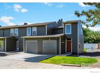 Contemporary gray townhouse with two-car garage, grassy area, and front door at 5415 W 16Th Ave, Lakewood, CO 80214