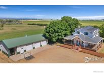 Beautiful farmhouse with large garage, situated on expansive land with mountain views at 5416 County Road 36, Platteville, CO 80651