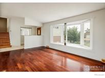 Bright living room featuring hardwood floors and a large bay window offering lots of natural light at 7210 Otis Ct, Arvada, CO 80003