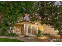 Charming home with stone accents, manicured landscaping, and a cozy front porch at 8416 Everett Way, Arvada, CO 80005