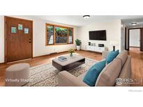 Bright living room featuring hardwood floors, a large window, and modern decor at 1247 Linden St, Longmont, CO 80501