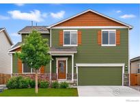 Charming two-story home with green siding, orange shutters, manicured lawn, and an attached two-car garage at 2310 Angus St, Mead, CO 80542
