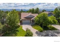 Charming home with a well-maintained lawn, mature trees, and mountain views at 2384 Ponderosa Pl, Erie, CO 80516