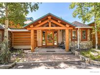 Welcoming entrance with log beams, custom front door and stacked stone accents at 24043 Eagle Cliff Trl, Conifer, CO 80433