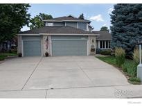 Charming home featuring a three-car garage, manicured lawn, and neutral-toned exterior, showcasing curb appeal at 2465 Mapleton Cir, Longmont, CO 80503