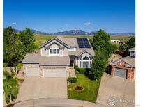 Stunning two-story home featuring a three-car garage, solar panels, lush lawn, and scenic mountain views at 345 Onyx Way, Superior, CO 80027