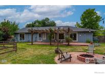 Spacious backyard with stone patio, pergola, firepit, and lush lawn offers a relaxing outdoor retreat at 419 Centennial Dr, Louisville, CO 80027