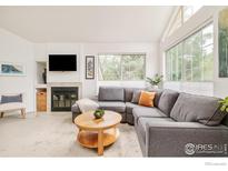 Bright living room with a fireplace, large windows, and comfortable gray sectional sofa at 4887 White Rock Cir # F, Boulder, CO 80301