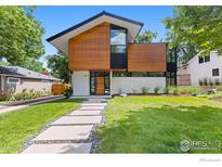 Striking modern home featuring unique wood facade, manicured lawn, and inviting stone pathway at 550 Iris Ave, Boulder, CO 80304