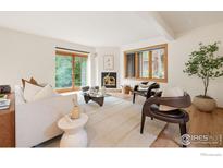 Bright living room featuring a stylish fireplace, modern furniture, and lots of natural light at 701 Kalmia Ave, Boulder, CO 80304