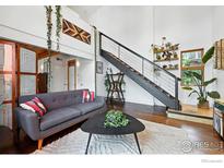 Bright living room featuring modern decor, high ceilings, and a stylish staircase at 801 Confidence Dr # 15, Longmont, CO 80504