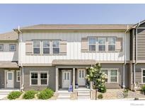 Two-story townhouse with gray and white siding, complemented by well-maintained landscaping at 897 Winding Brook Dr, Berthoud, CO 80513