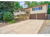 Charming two-story home featuring a welcoming front porch and a well-maintained front yard with mature trees at 1209 S Terry St, Longmont, CO 80501