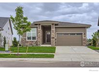 Charming single-Gathering home featuring a two-car garage, stone accents, and a well-manicured lawn at 3166 Newfound Lake Rd, Berthoud, CO 80513