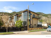 Modern townhome with wood and dark gray accents, featuring a balcony and sleek design at 358 Arapahoe Ave # B, Boulder, CO 80302