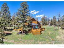 A beautiful view of a wood-sided home with a spacious deck nestled amongst the trees at 394 Deer Trail Cir, Boulder, CO 80302