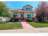Charming home with a well-manicured lawn, red brick accents and colorful trees at 4926 Pasadena Way, Broomfield, CO 80023