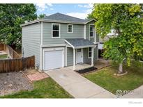 Charming two-story home featuring a well-manicured lawn, attached garage, and welcoming front porch at 5225 E 100Th Dr, Thornton, CO 80229