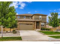 Charming two-story home with a stone and siding exterior, featuring a two-car garage and landscaped front yard at 71 Sugar Beet Cir, Longmont, CO 80501