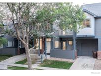 Charming townhome with covered porch, gray siding, and well-maintained landscaping at 829 Kane Dr # 23, Longmont, CO 80501