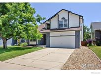 Charming two-story home featuring a two-car garage, well-maintained lawn, and a mature shade tree at 988 W Dahlia St, Louisville, CO 80027