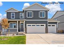 Beautiful two-story home featuring a two-car garage, covered porch, and manicured lawn under construction at 1038 Scotts Peak Dr, Berthoud, CO 80513