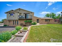 Charming two-story home with a brick exterior, balcony, landscaped yard and unique decorative touches at 13748 Downing St, Brighton, CO 80602