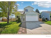 Charming two-story home featuring a well-maintained lawn and a two car attached garage at 1506 Crestwood Cir, Longmont, CO 80504