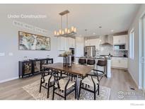 Bright dining room featuring a dark wood table, decorative lighting, and contemporary decor at 2715 Crystal Springs Ln, Longmont, CO 80503