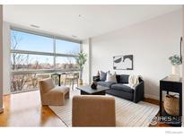 Bright living room featuring large windows and modern furnishings at 2958 Syracuse St # 306, Denver, CO 80238