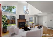 Bright living room featuring a fireplace, hardwood floors, and large windows for ample natural light at 5174 Buckingham Rd, Boulder, CO 80301