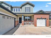 Charming two-story home features a mix of brick and siding, with a well-maintained front yard and attached two-car garage at 7372 E 129Th Pl, Thornton, CO 80602