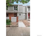 Charming townhome with gray siding, brick accents, and rock landscaping at 7474 E Arkansas Ave # 12, Denver, CO 80231