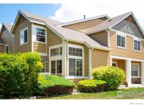 Two-story home featuring yellow siding, white trim, well-maintained landscaping, and numerous windows at 805 Summer Hawk Dr # B7, Longmont, CO 80504