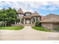 Elegant brick home with turret-style architecture, manicured lawn, and inviting entrance at 8337 Greenwood Dr, Niwot, CO 80503