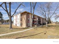 Charming multi-Gathering building with brick accents, balconies, and mature trees, offering a serene living environment at 12114 Melody Dr, Denver, CO 80234