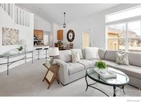 Bright living room with a modern sectional sofa, vaulted ceilings, and neutral decor at 14214 Waterside Ln, Broomfield, CO 80023
