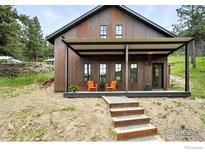 Stylish home featuring unique corrugated metal facade, a covered porch, and a welcoming gravel pathway at 360 Boulder St, Boulder, CO 80302