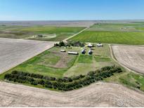 Expansive aerial view showcases the farm with its buildings and grain silos amid surrounding fields at 47285 E 112Th Ave, Bennett, CO 80102