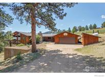 View of a charming wooden home featuring an attached garage and surrounded by mature trees at 474 Leonards Rd, Boulder, CO 80302
