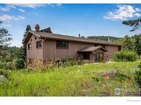 Two-story home with a rustic exterior and lush surroundings under a bright sky at 853 Deer Trail Rd, Boulder, CO 80302