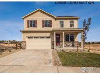 Two-story home featuring a two-car garage, stone accents, and well-manicured lawn at 9935 Ceylon Ct, Commerce City, CO 80022
