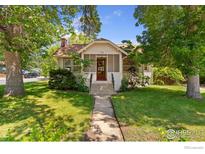 Charming bungalow featuring a landscaped yard and welcoming front porch at 1220 9Th Ave, Longmont, CO 80501
